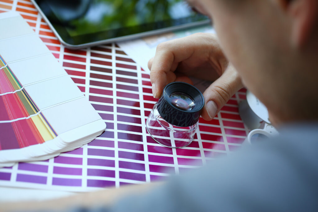 male serviceman hold in hand magnifying glass making colour test